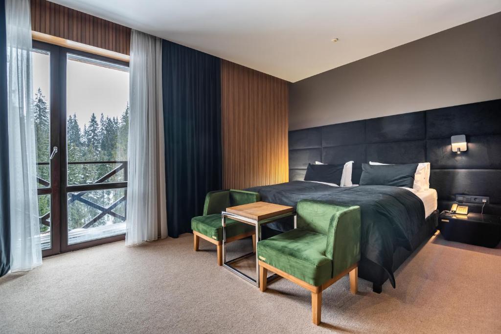 a bedroom with a bed and a table and a chair at MK Resort (ex. Magiya Karpat) in Bukovel