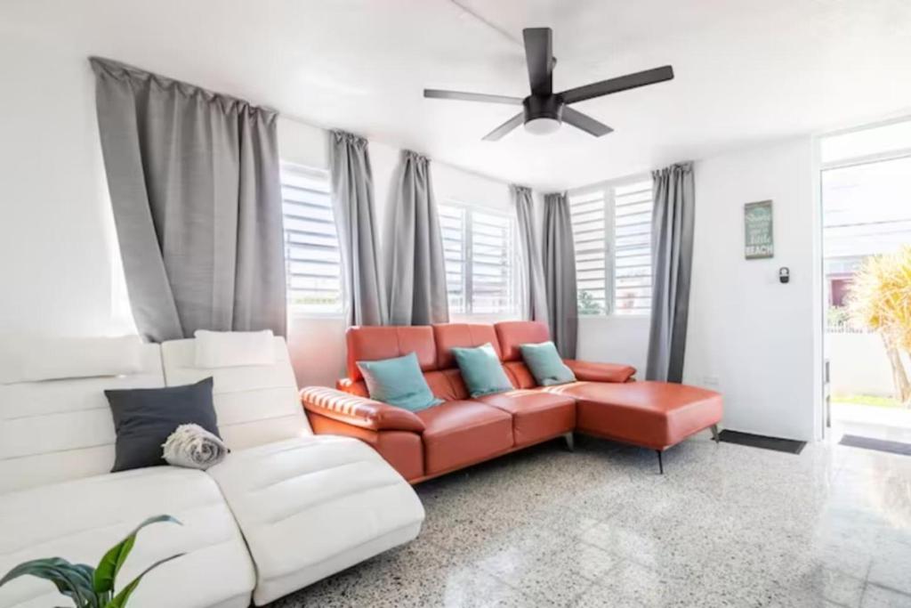 sala de estar con sofá y ventilador de techo en Encanto house with king bed, en Isabela