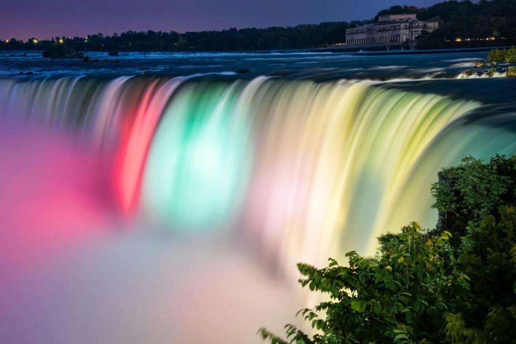 een regenboog midden in een waterval bij Serenity by the Falls - Modern 2 Bedroom Hideaway in Niagara Falls