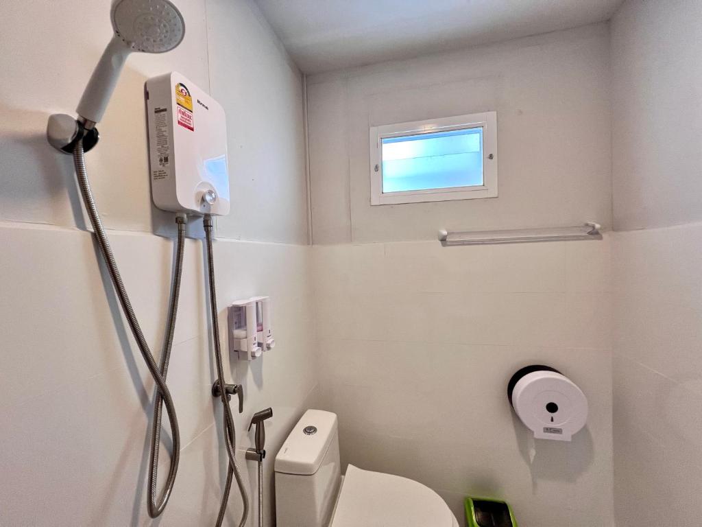 La petite salle de bains est pourvue d'une douche et de toilettes. dans l'établissement MrT Riverside Sampran มิสเตอร์ที โฮมสเตย์-ทองกวาว, à Sam Phran