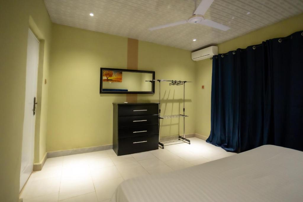 1 dormitorio con 1 cama y vestidor con espejo en Furnished 1 Bedroom Apartment in Accra, en Accra