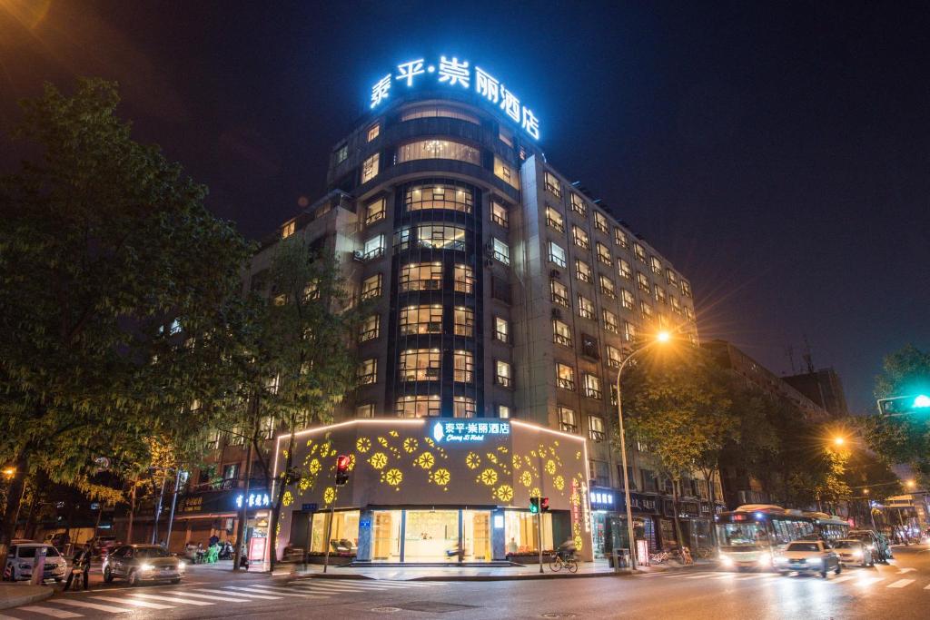 a building with a sign on top of it at night at Chong Li Hotel Chengdu in Chengdu