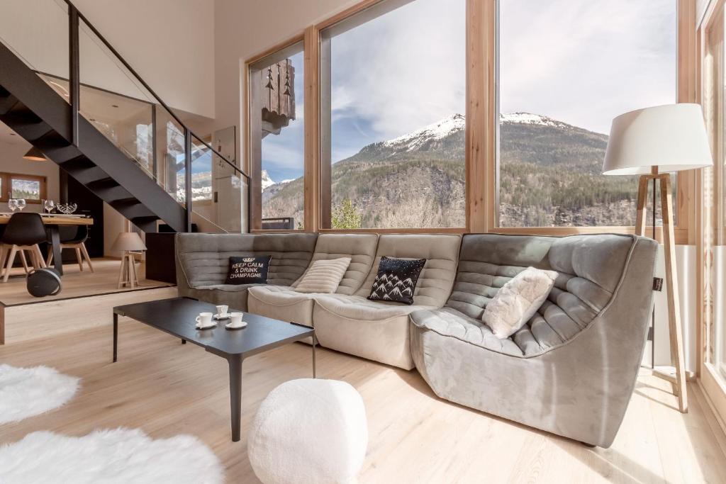 sala de estar con sofá y ventana grande en Chalet Kieppi - View off Mont-Blanc range, en Les Houches