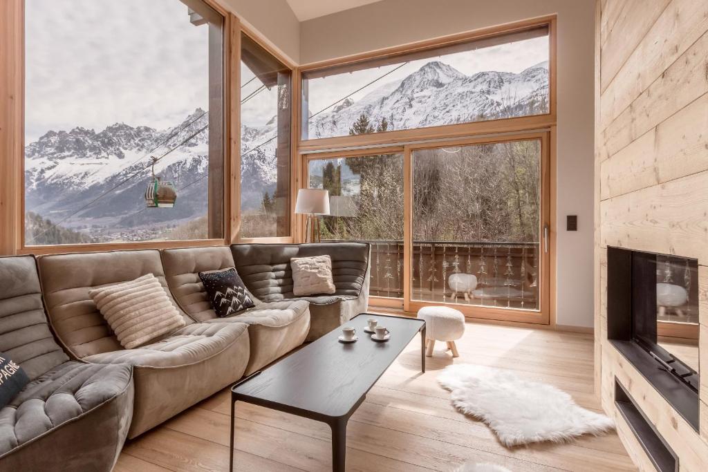 un salon avec un canapé et une grande fenêtre dans l'établissement Chalet Kieppi - View off Mont-Blanc range, aux Houches