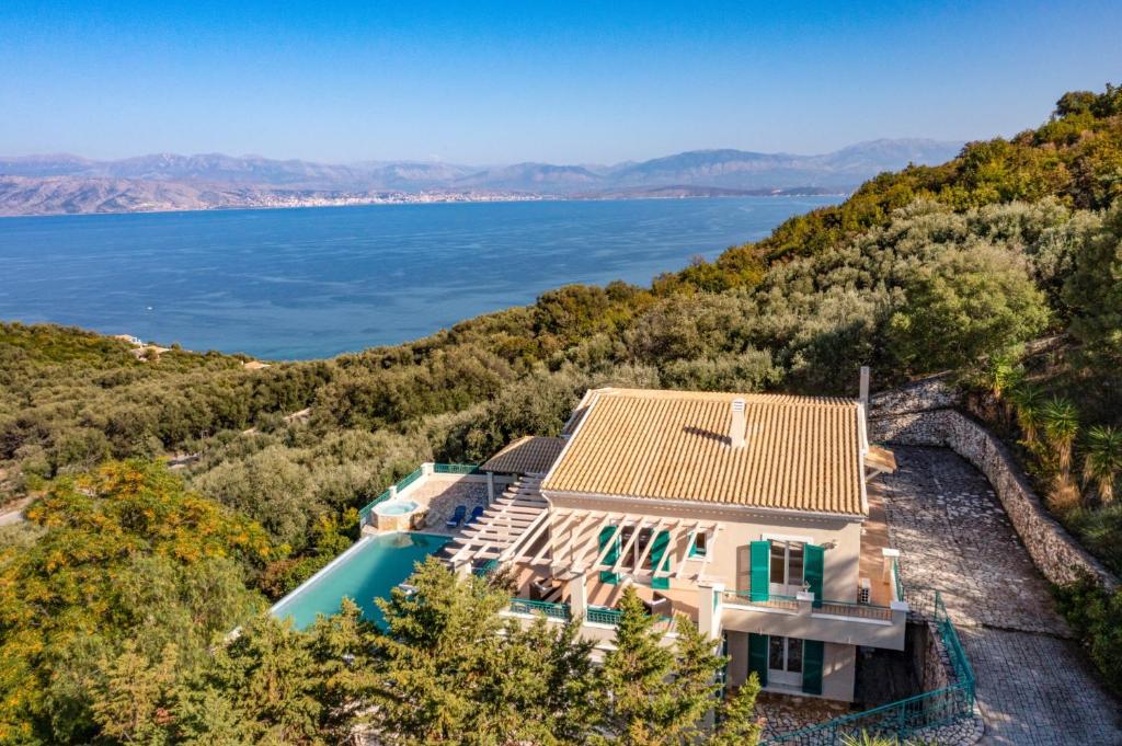 an aerial view of a house on a hill next to the water at Villa Panorama Andrea by Villa Plus in Ágios Ilías