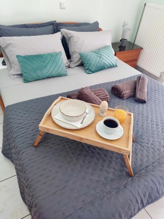 a tray with plates and cups of coffee on a bed at Igoumenitsa Retiré Apartment in Igoumenitsa