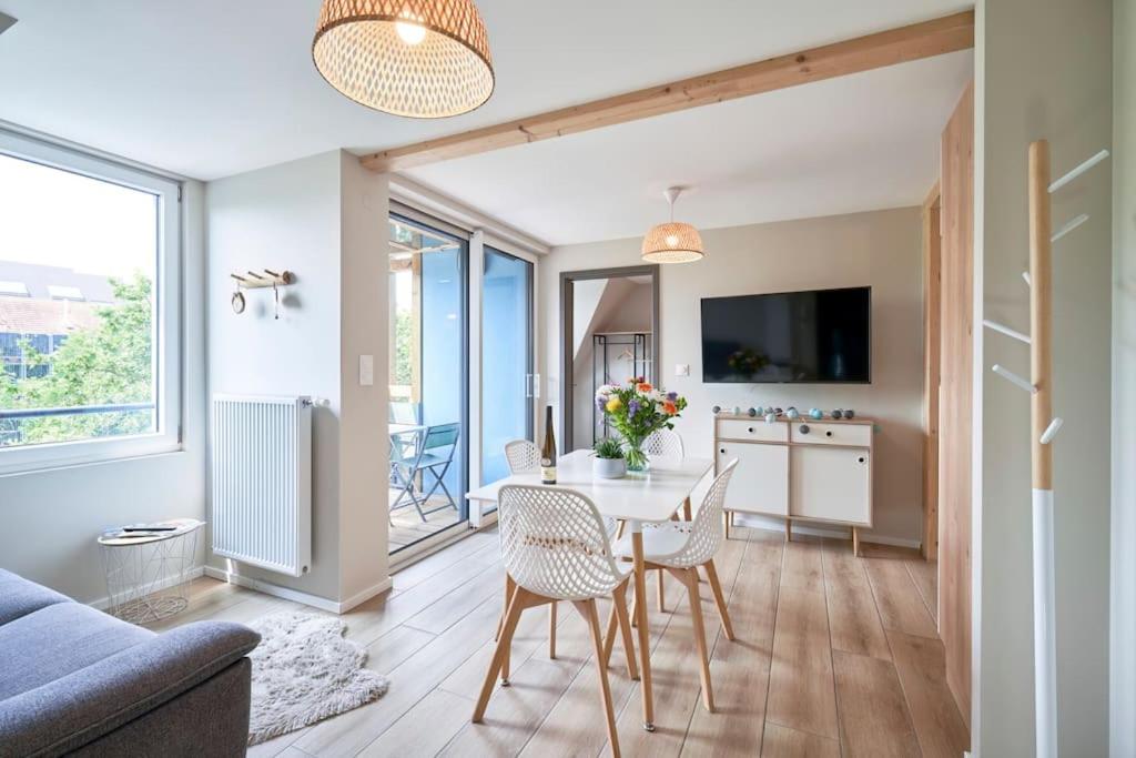 un salon avec une table et des chaises dans l'établissement Le SCANDINAVE Centre Ville/2 chambres + Terrasse, à Colmar
