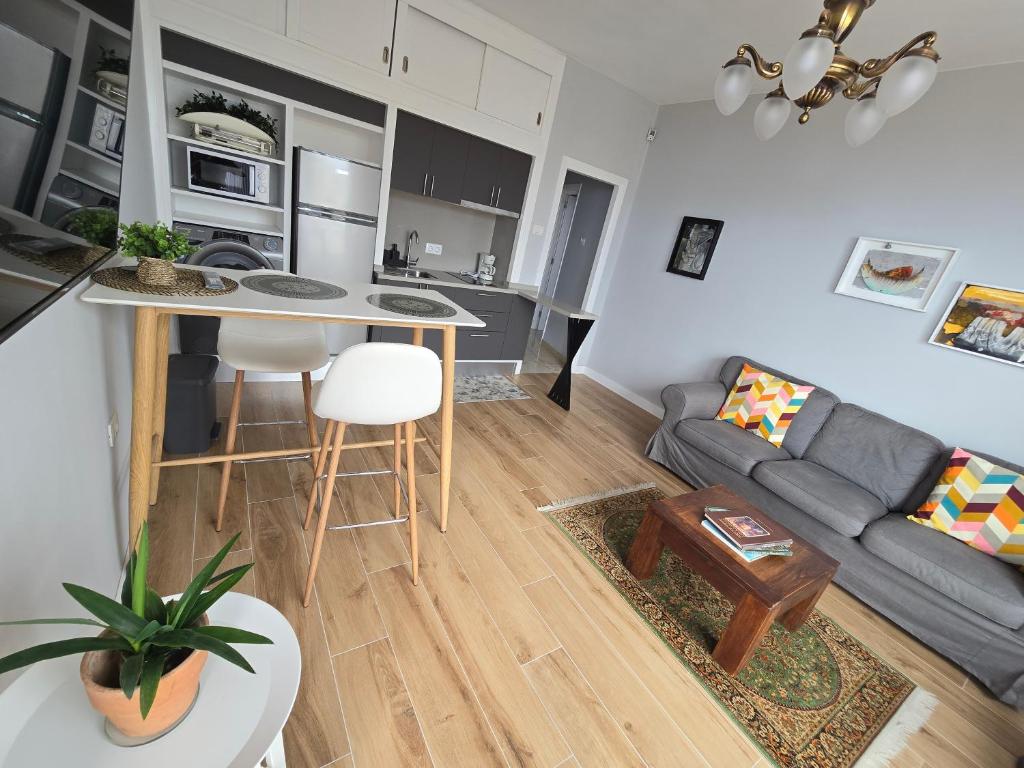 een woonkamer en een keuken met een bank en een tafel bij Apartamento Drago in Santa Cruz de Tenerife