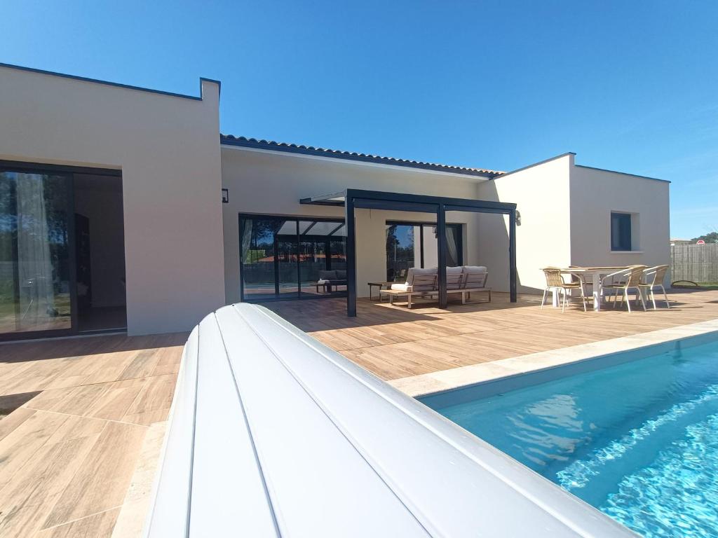 une maison avec une piscine et une terrasse dans l'établissement Maison neuve 200m2 climatisée, proche de la plage et des commerces, à Audenge