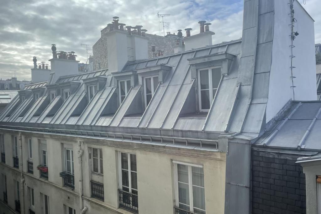 ein Dach eines Gebäudes mit Fenstern darauf in der Unterkunft Parisian apartment on courtyard in Paris
