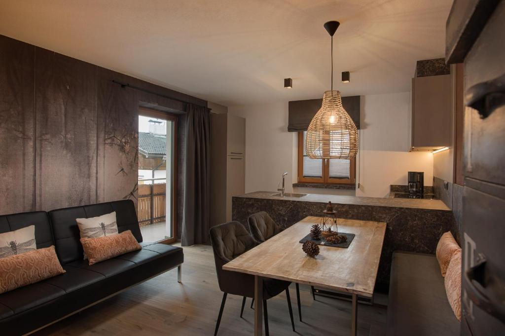 ein Wohnzimmer mit einem Tisch und einem Sofa in der Unterkunft Residence Alpenrose in St. Johann im Ahrntal