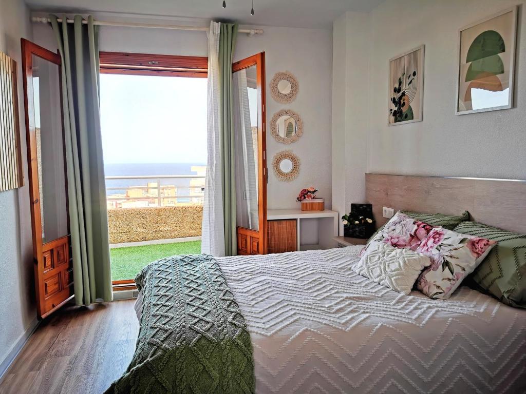 Costamar playa arenales del sol في آريناليس ديل سول: غرفة نوم مع سرير وإطلالة على المحيط