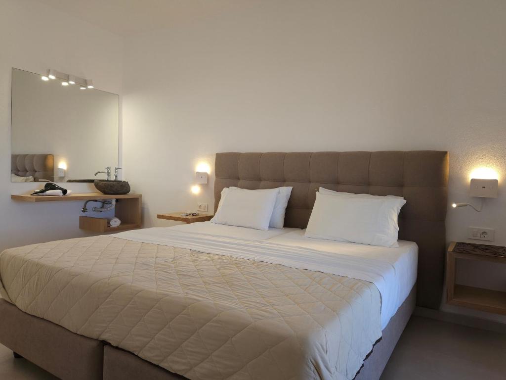 een slaapkamer met een groot bed met 2 witte kussens bij Boomerang Sea View Accommodation and Studios in Plános