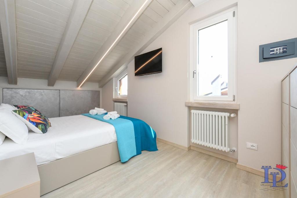 ein kleines Schlafzimmer mit einem Bett und einem Fenster in der Unterkunft Desenzanoloft H2o in Desenzano del Garda