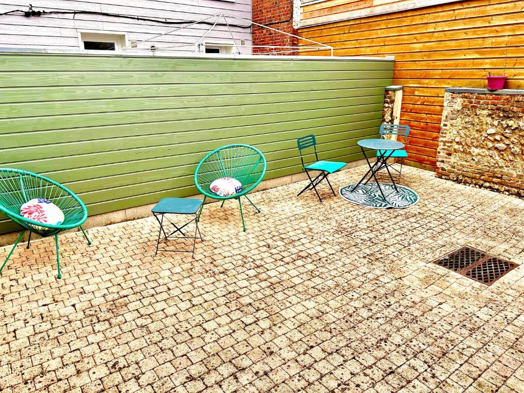 un groupe de chaises et de tables devant une clôture dans l'établissement La vacancière - 308, à Rouen