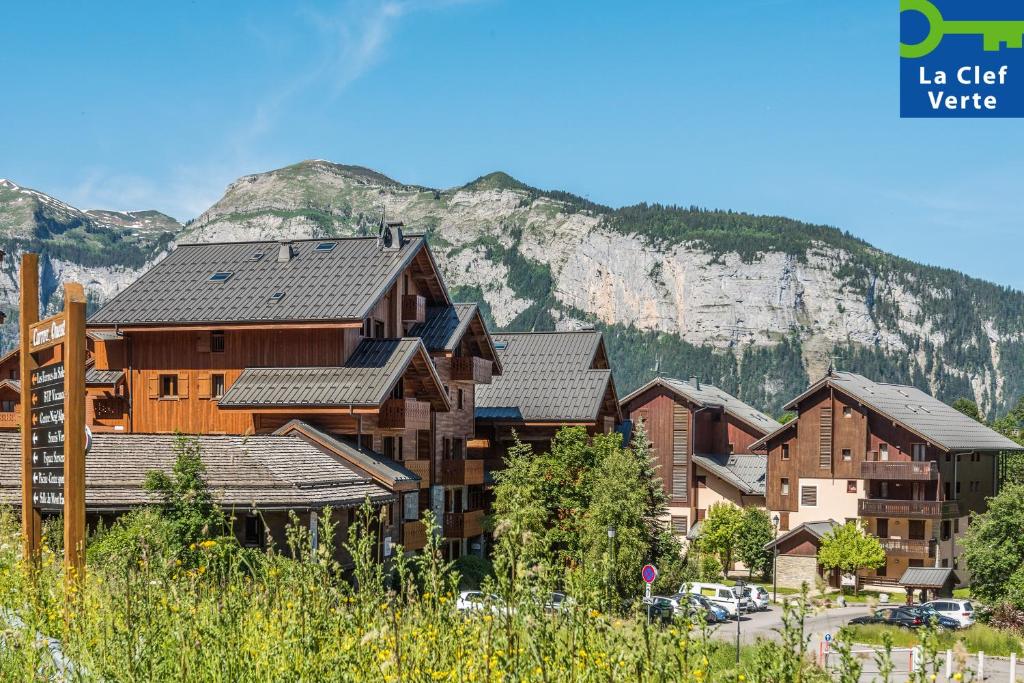 un grupo de edificios frente a una montaña en Résidence Pierre & Vacances Premium Les Fermes Du Soleil, en Les Carroz d'Araches