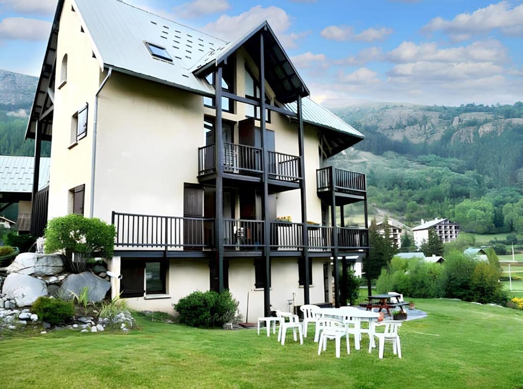 ル・モネティエ・レ・バンにあるAppartement de 4 chambres avec balcon amenage et wifi a Le Monetier les Bains a 1 km des pistesの建物の前にテーブルと椅子