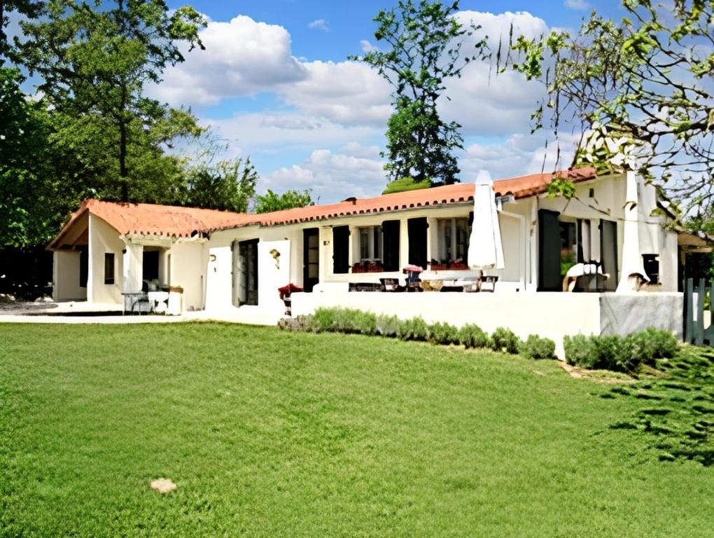 una casa con césped delante en Villa de 3 chambres avec piscine partagee sauna et jardin clos a Ecuras, en Écuras