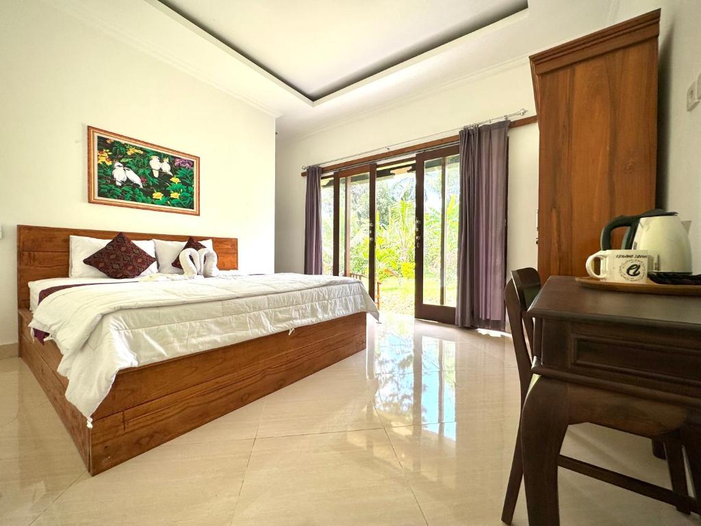 um quarto com uma cama, uma secretária e um piano em Asri Dana Guest House em Ubud