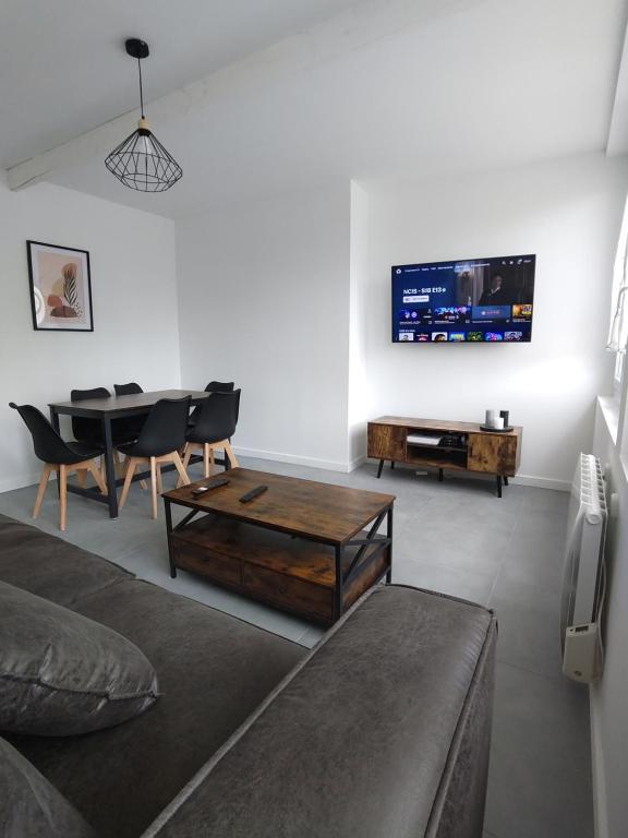 un salon avec un canapé, une table et une télévision dans l'établissement Appartement lumineux et spacieux 70m2 proche de tout - 3 chambres, à Nantes