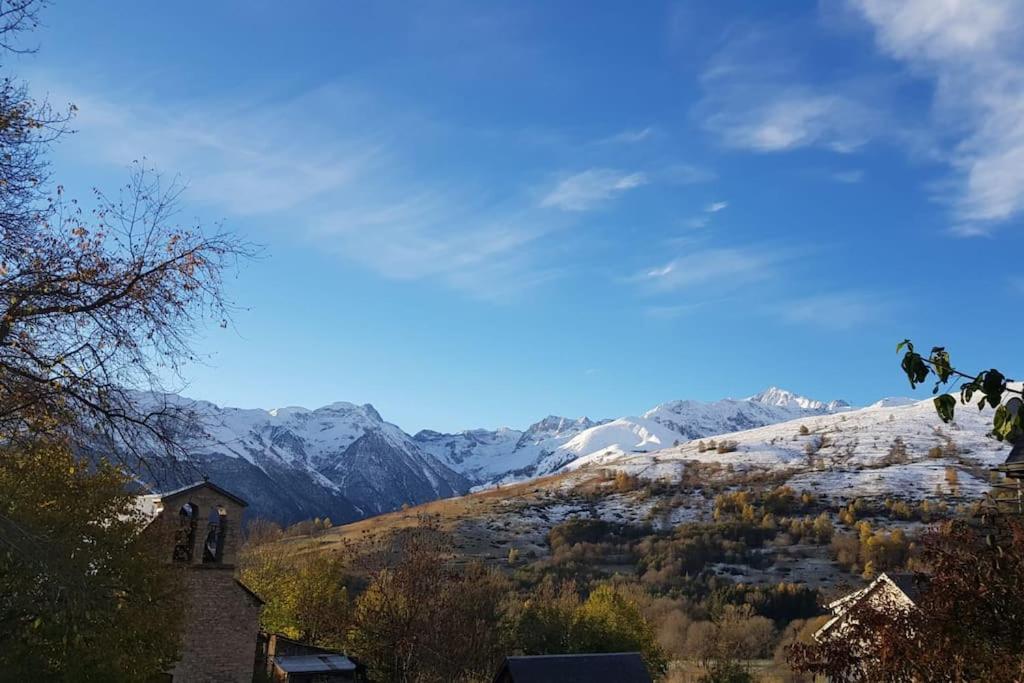 - une vue sur une montagne enneigée avec une église dans l'établissement Maison Pyrénées - Poubeau, à Poubeau