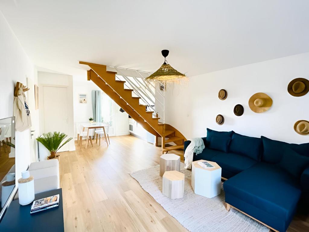 sala de estar con sofá azul y escalera en Bord de mer, maison paisible et rénovée à Penvins, en Sarzeau