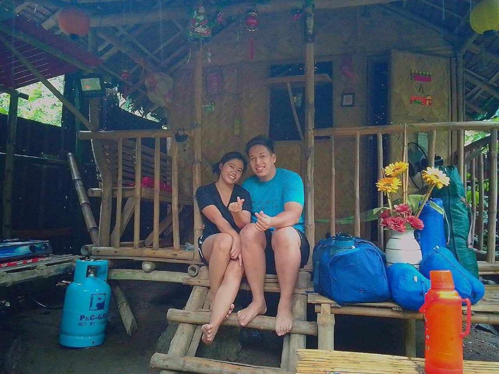 a man and a woman sitting on a bench at YOUMEBED MOTOR INN at Kambal Kubo Resthouse in Antipolo