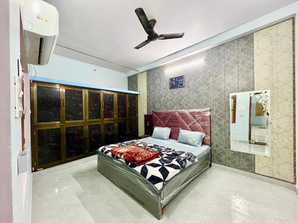- une chambre avec un lit et un ventilateur de plafond dans l'établissement Trilok Residency - Dashashwamedh Varanasi, à Varanasi