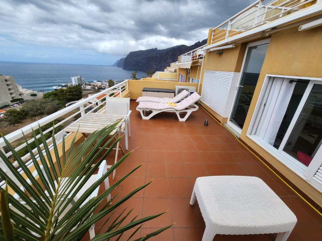 einen Balkon mit Stühlen und Meerblick in der Unterkunft Los Gigantes,huge terrace,sea view,air conditioning in Puerto de Santiago