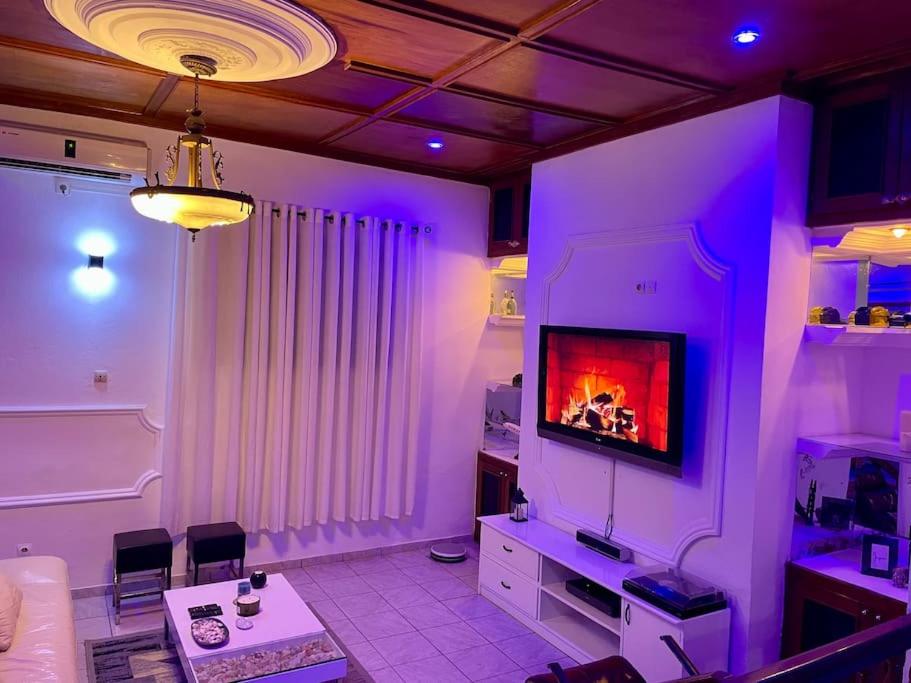 a living room with a tv and purple lighting at Mini villa cosy et discrete in Douala