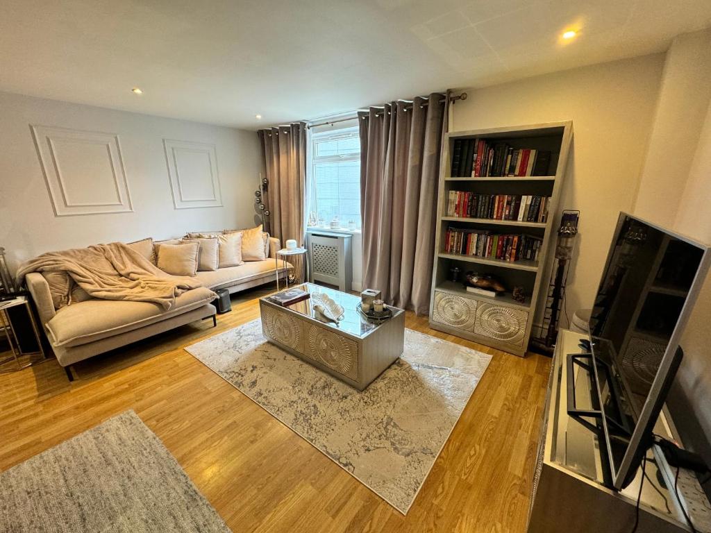 a living room with a couch and a tv at Juli’s cosy home in London