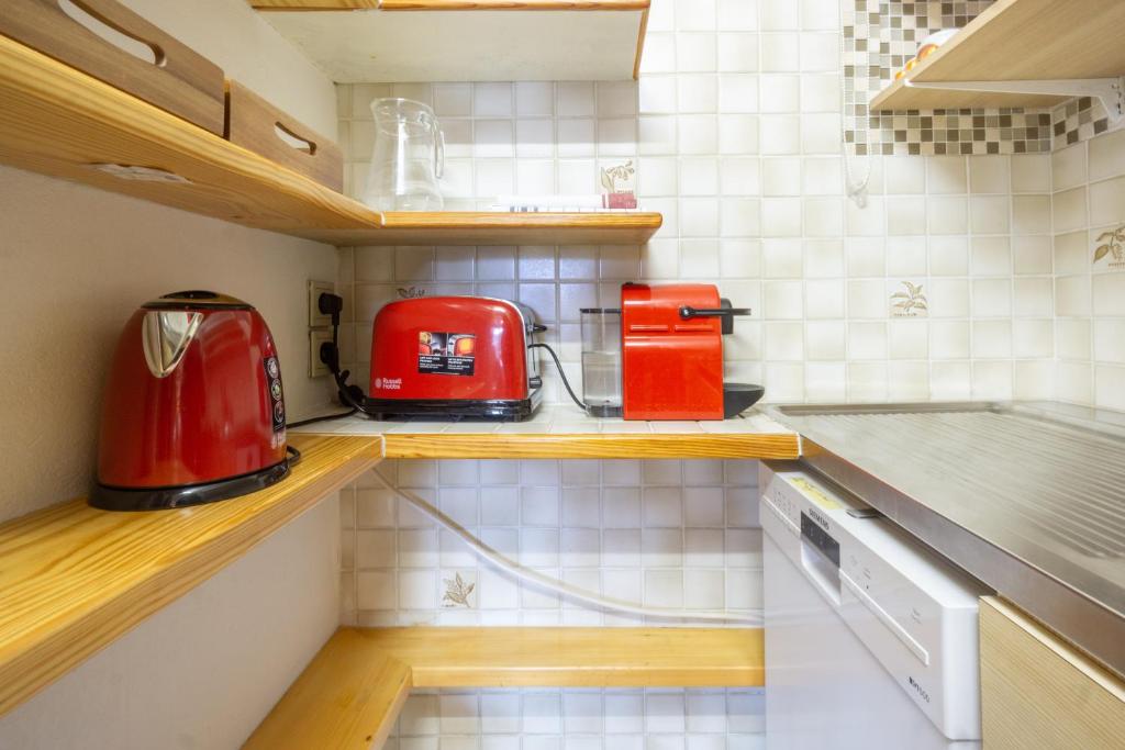 eine kleine Küche mit roten Geräten auf der Theke in der Unterkunft Les marmottes in Courchevel