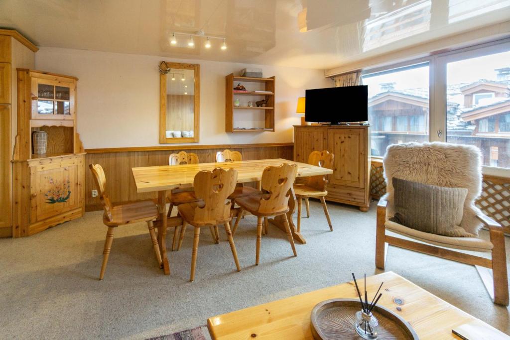 a living room with a wooden table and chairs at Les marmottes in Courchevel
