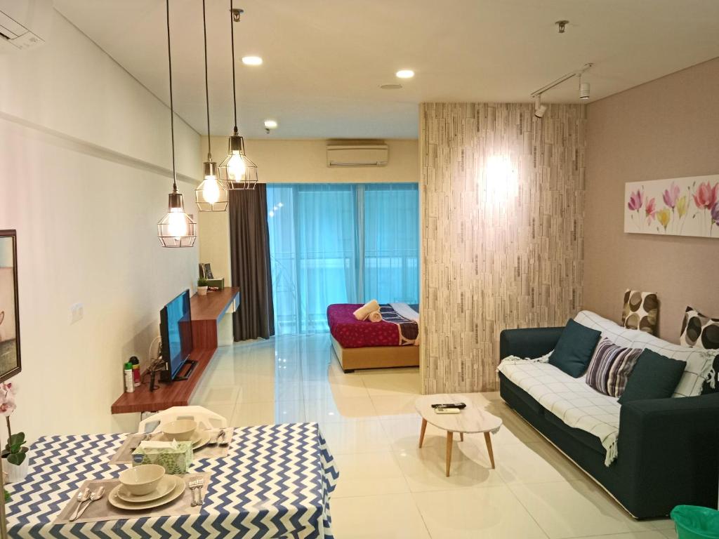 uma sala de estar com um sofá e uma mesa em Summer Service Suite Klcc By CityBox em Kuala Lumpur