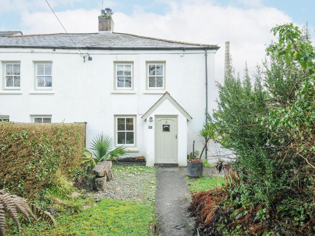 a white house with a white door at Cobb Cottage in St Austell