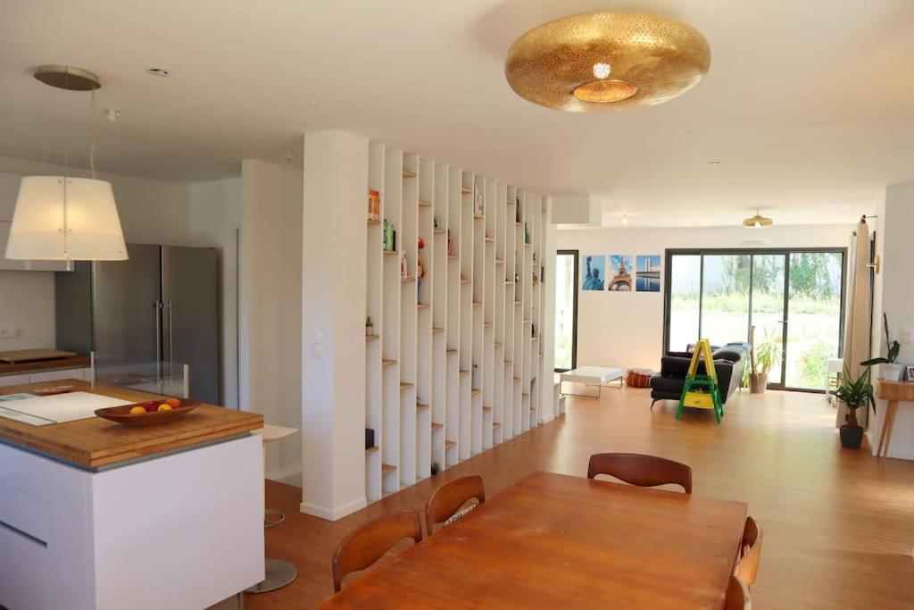 cocina y sala de estar con mesa y comedor en Maison moderne et confortable en bordure de forêt, en Poissy
