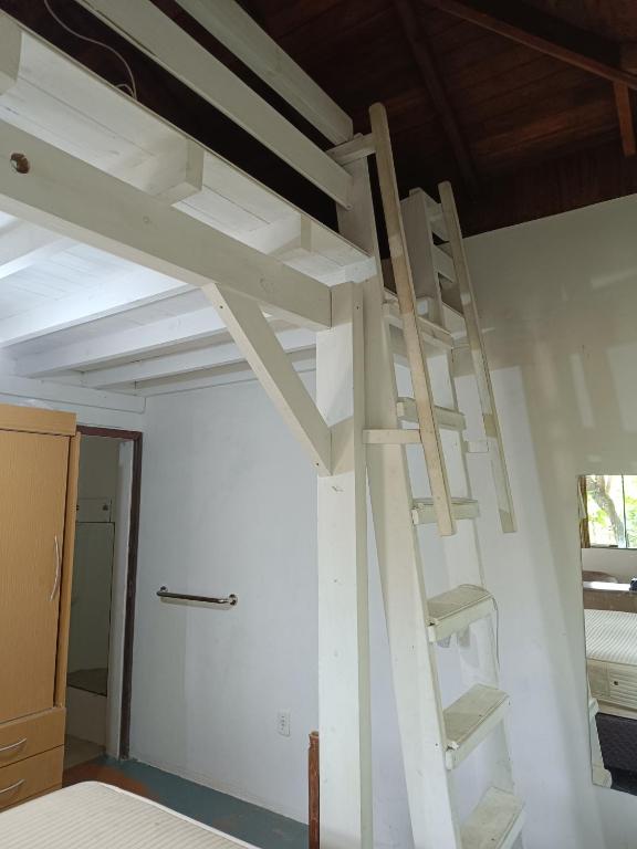 uma escada branca num quarto com tecto em Chalé Beija Flor em Porto Belo