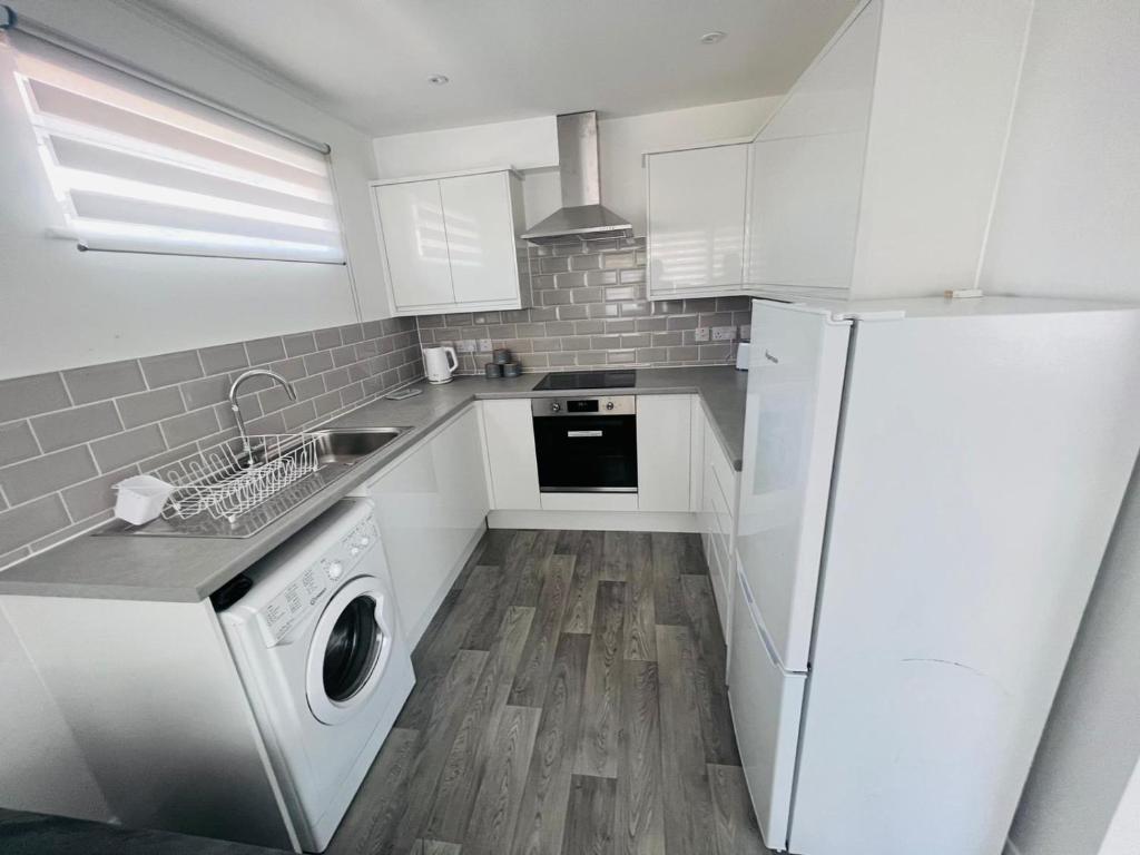 cocina con nevera blanca y lavavajillas en pro-let one bed apartment Ipswich sleeps up to 4 en Westerfield