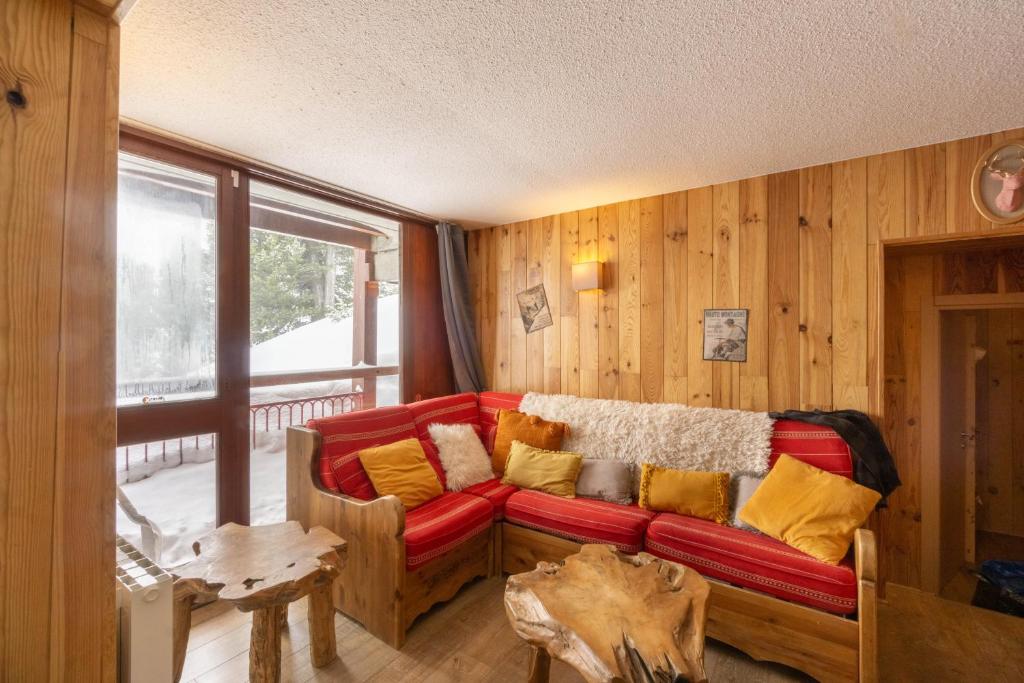 a living room with a red couch with yellow pillows at Arc 2000 appartement type chalet in Bourg-Saint-Maurice