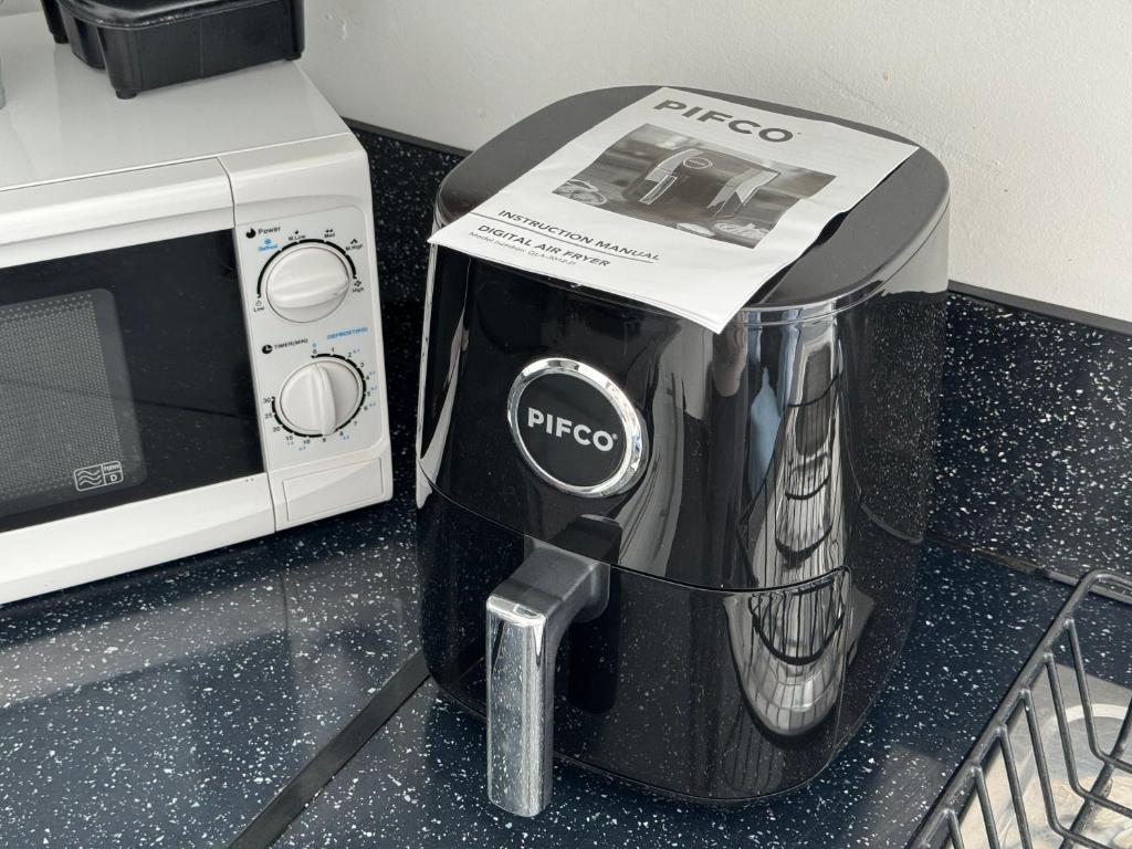 a coffee maker with a box on it next to a microwave at Winter Gardens Flat 3 - Family Apartment in Blackpool