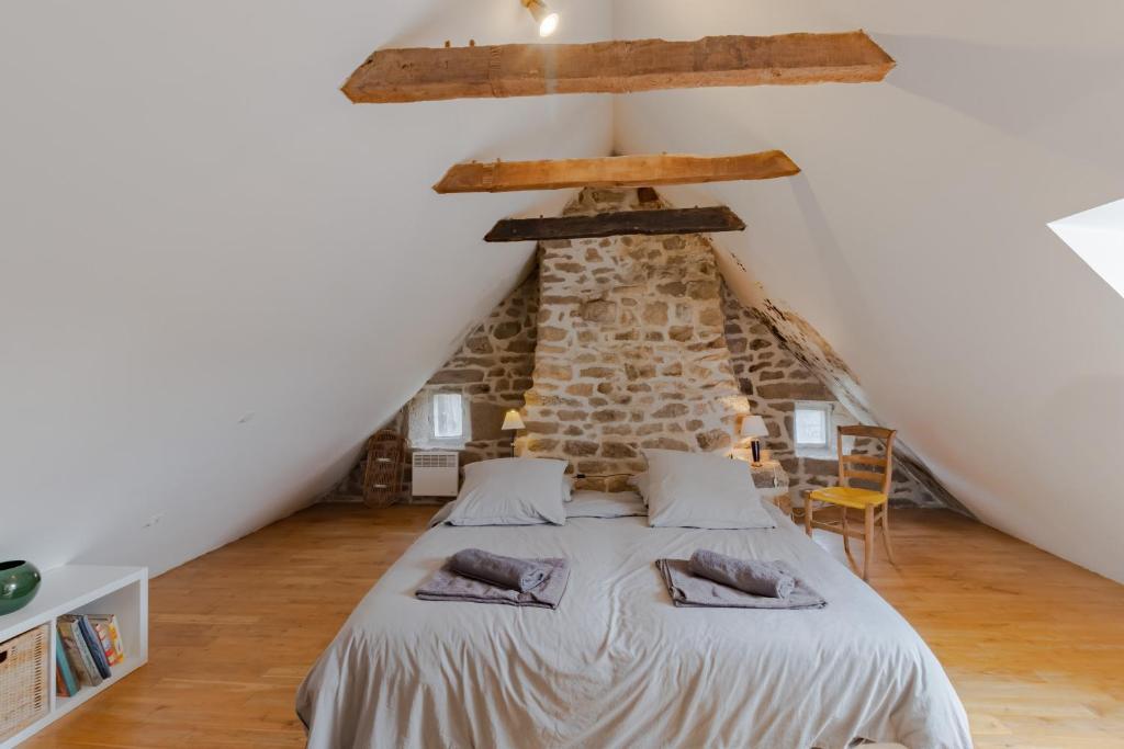 ein Schlafzimmer mit einem Bett im Dachgeschoss in der Unterkunft La maison de François in Chaumeil