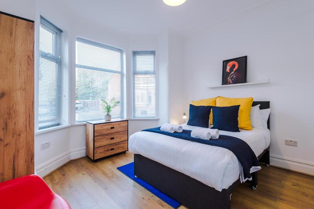 um quarto com uma cama grande e 2 janelas em Barton House - Sleeping 10 em Manchester