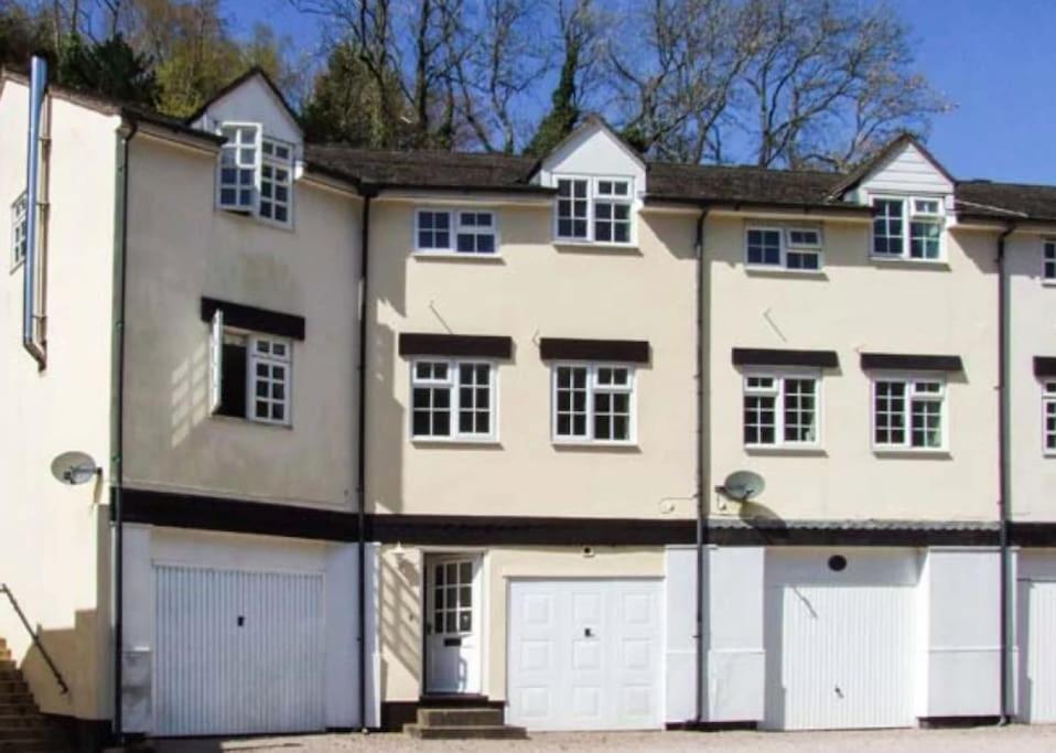 a large white house with two garage doors at 10 Wye Rapids Cottages in Symonds Yat