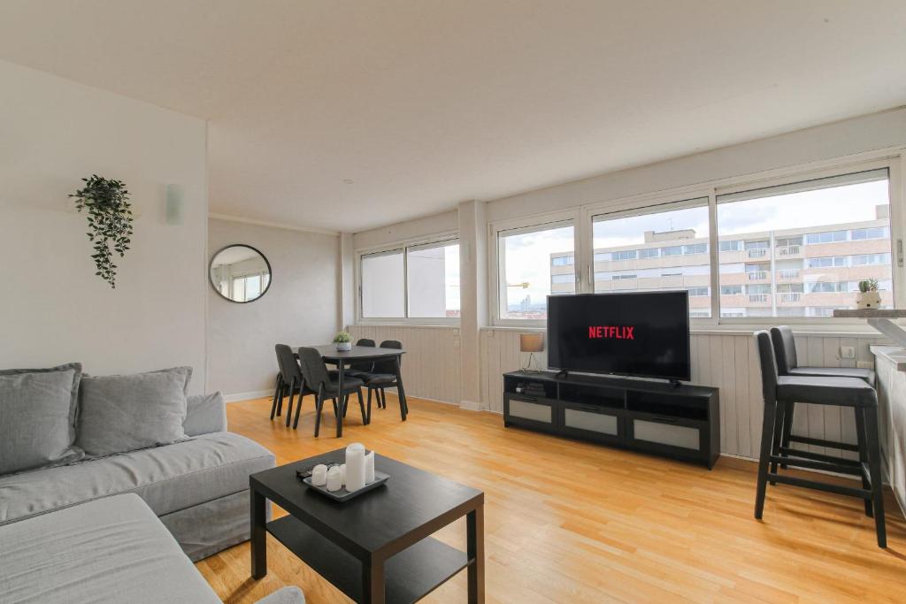 Il comprend un salon doté d'un canapé et d'une table avec une télévision. dans l'établissement Lumineux et Calme avec parking gratuit, à Villeurbanne