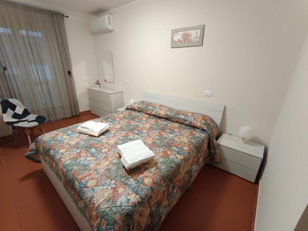 a hotel room with two beds and a chair at La Casetta per te in Gravina di Catania