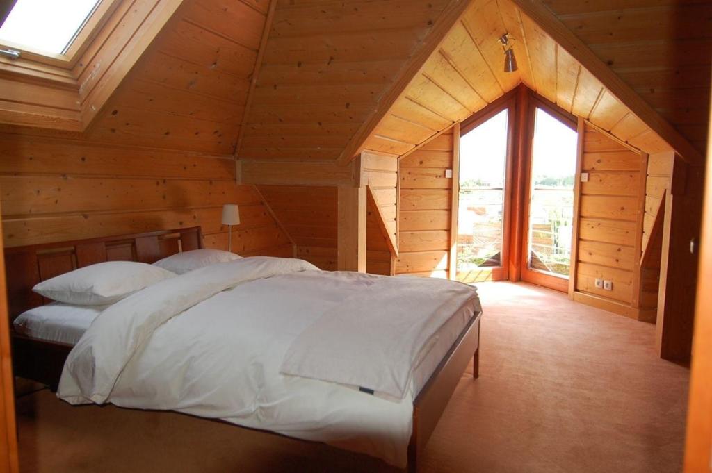 a bedroom with a large bed in a wooden room at Haus am Meer in Dębki