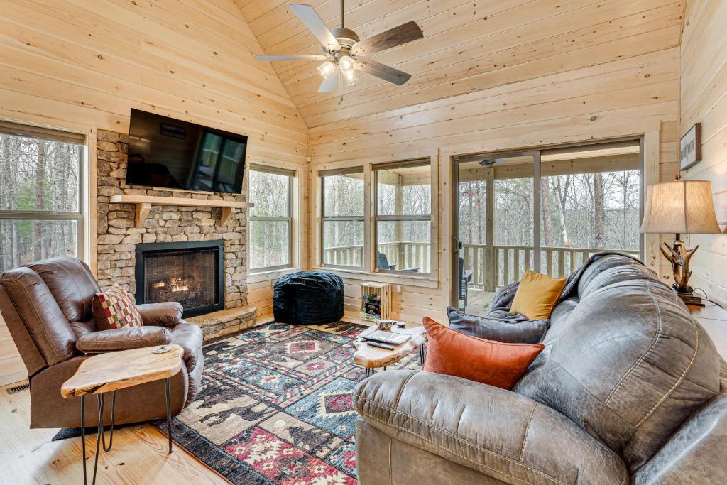 sala de estar con sofá y chimenea en Secluded Murphy Cabin Rental with Deck and Fire Pit!, en Turtletown