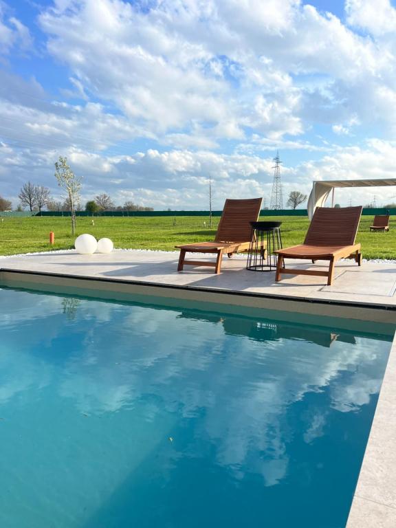 two chairs and a table next to a swimming pool at Villa Iris in Modena