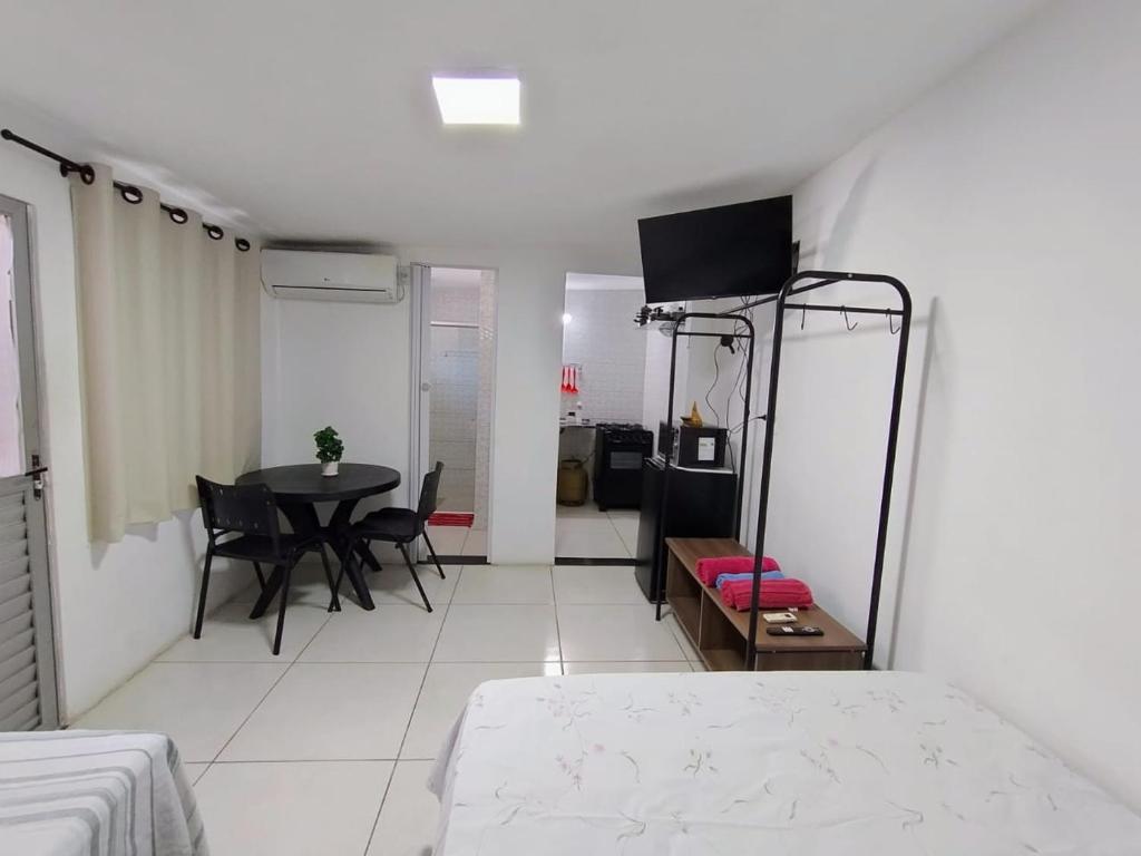 Cette chambre comprend un lit, une table et des chaises. dans l'établissement KITNET EM OLINDA CASA CAIADA A 50 MT DA PRAIA, à Olinda