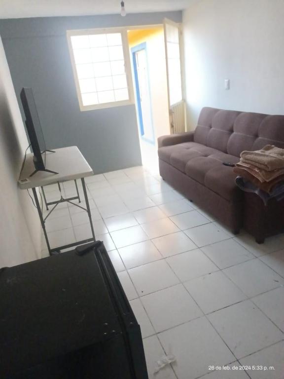a living room with a couch and a tv on a table at hermoso departamento un lugar para descansar 2 in Tlaxcala de Xicohténcatl